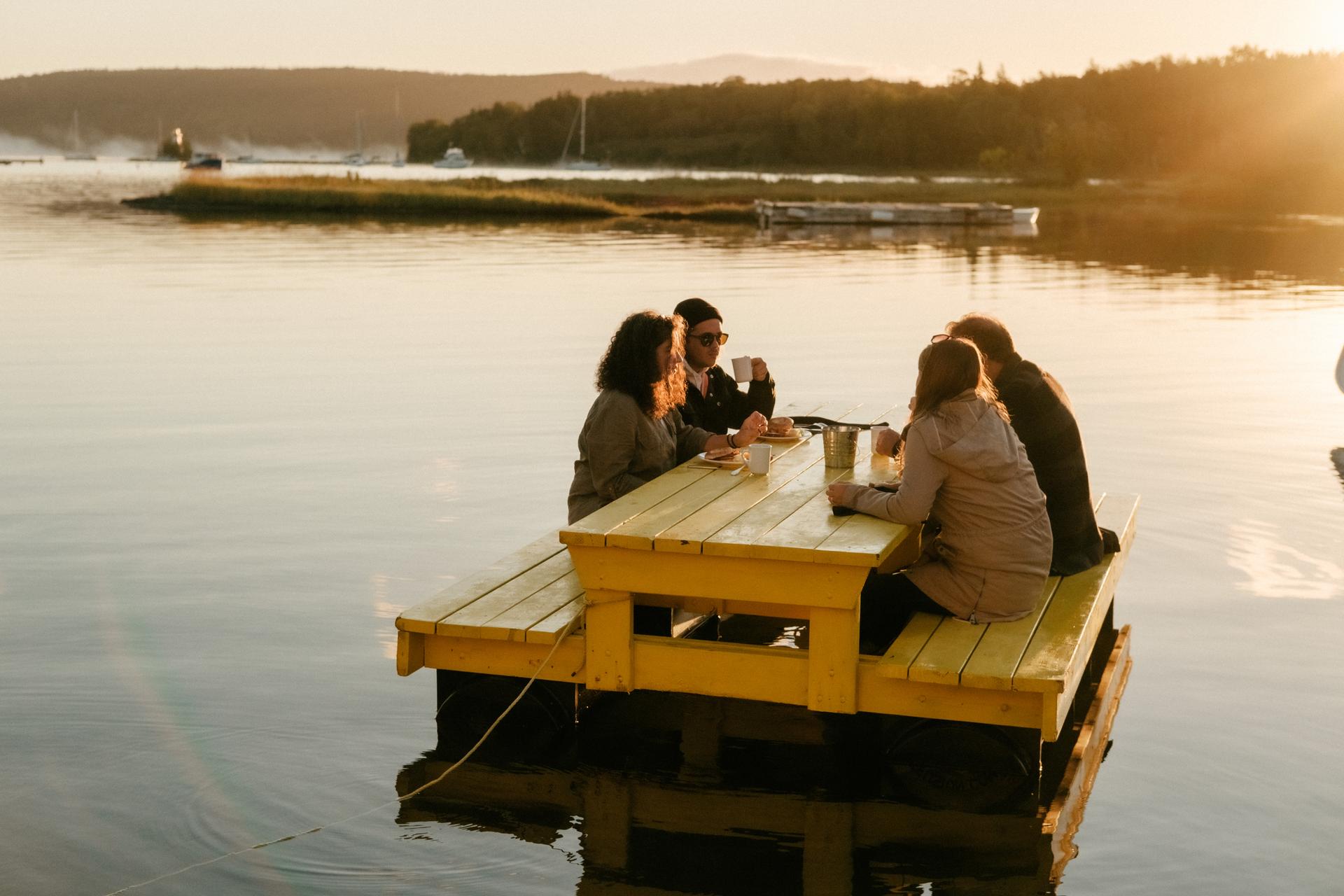 4 people sitting on floating picnic table