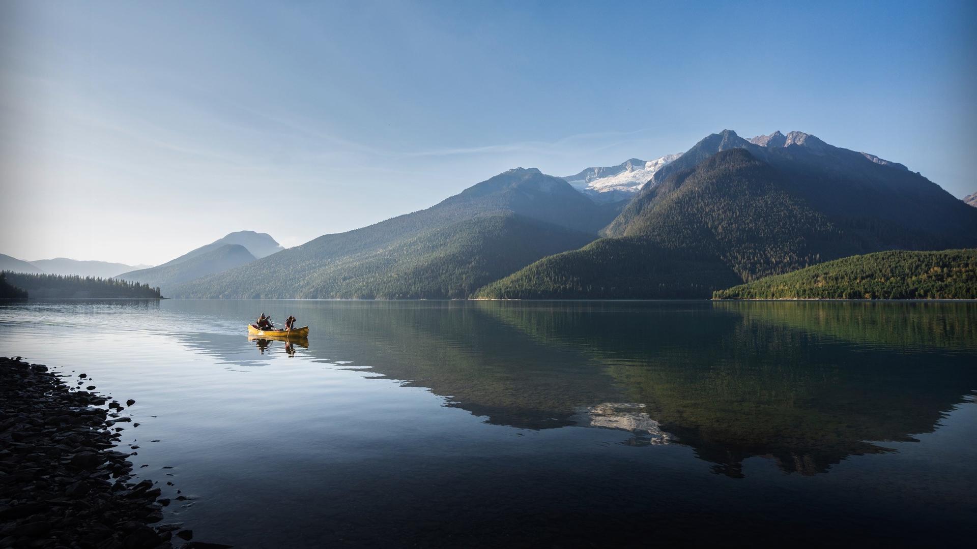 lake with two kayakers and mountains in the background