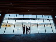 Three people looking out at a glass with views of Vancouver's mountains