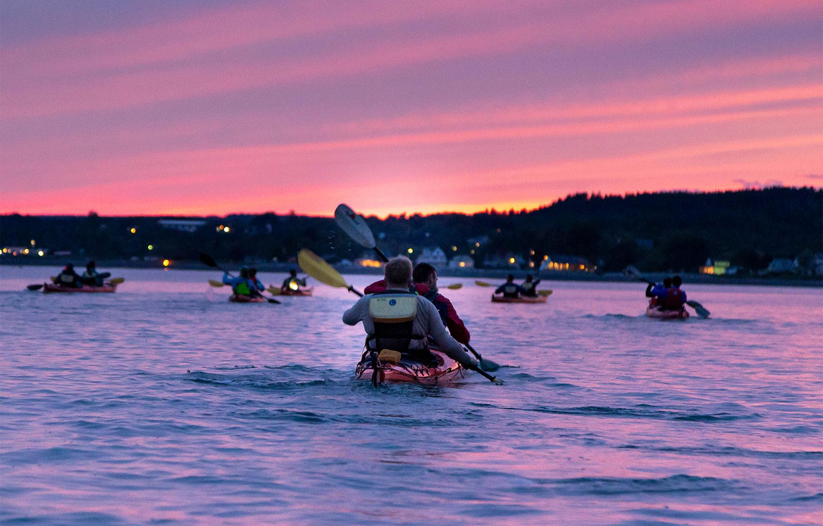 People kayaking at sunset in St. Martins on the Bay of Fundy