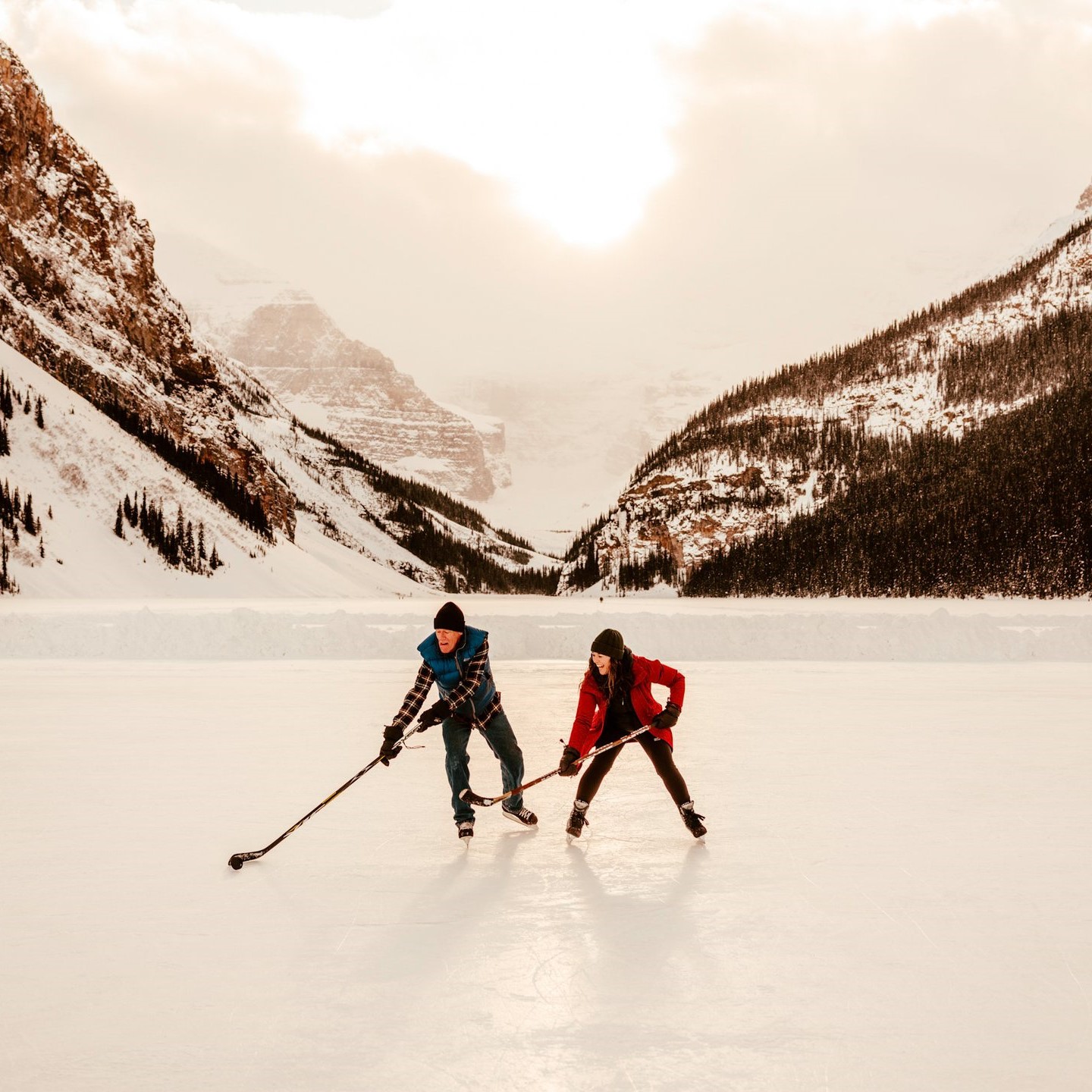 2 people playing hockey on a lake
